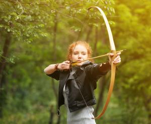 Junge Dame spannt den Bogen zum Abschuss