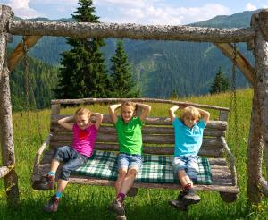 The children make themselves comfortable in the wooden Hollywood swing