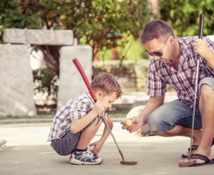Vater und Sohn beim Minigolf spielen