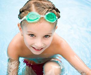 kleiner Junge freut sich im Hallenbad