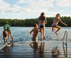 A group of young people jump into the bathing lake