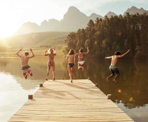 A group of young people jump into the water