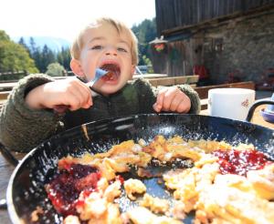 Ein kleiner Junge geniesst seinen Kaiserschmarrn